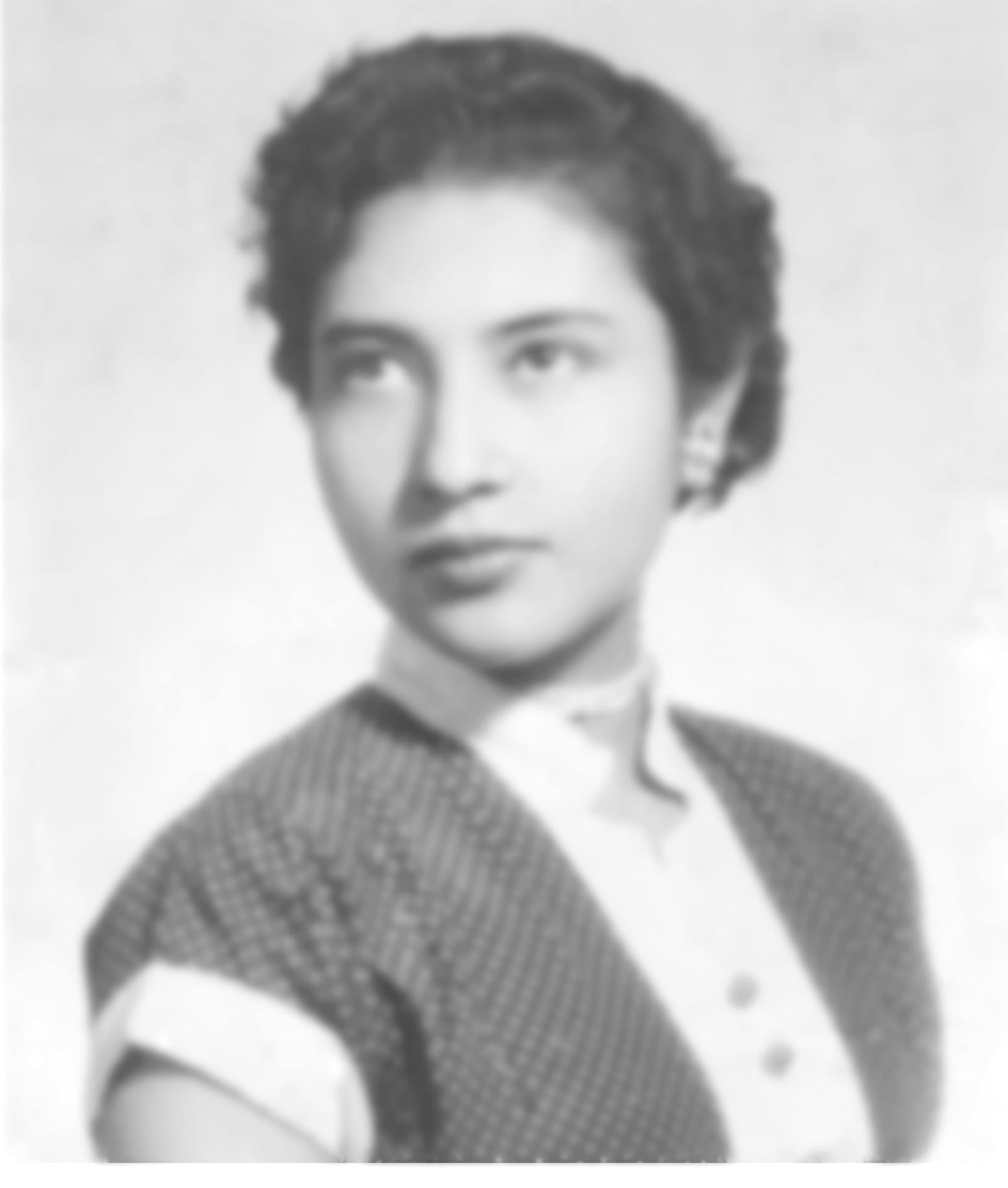 Foto tipo credencial pequeña, borrosa y con sello oficial antiguo
